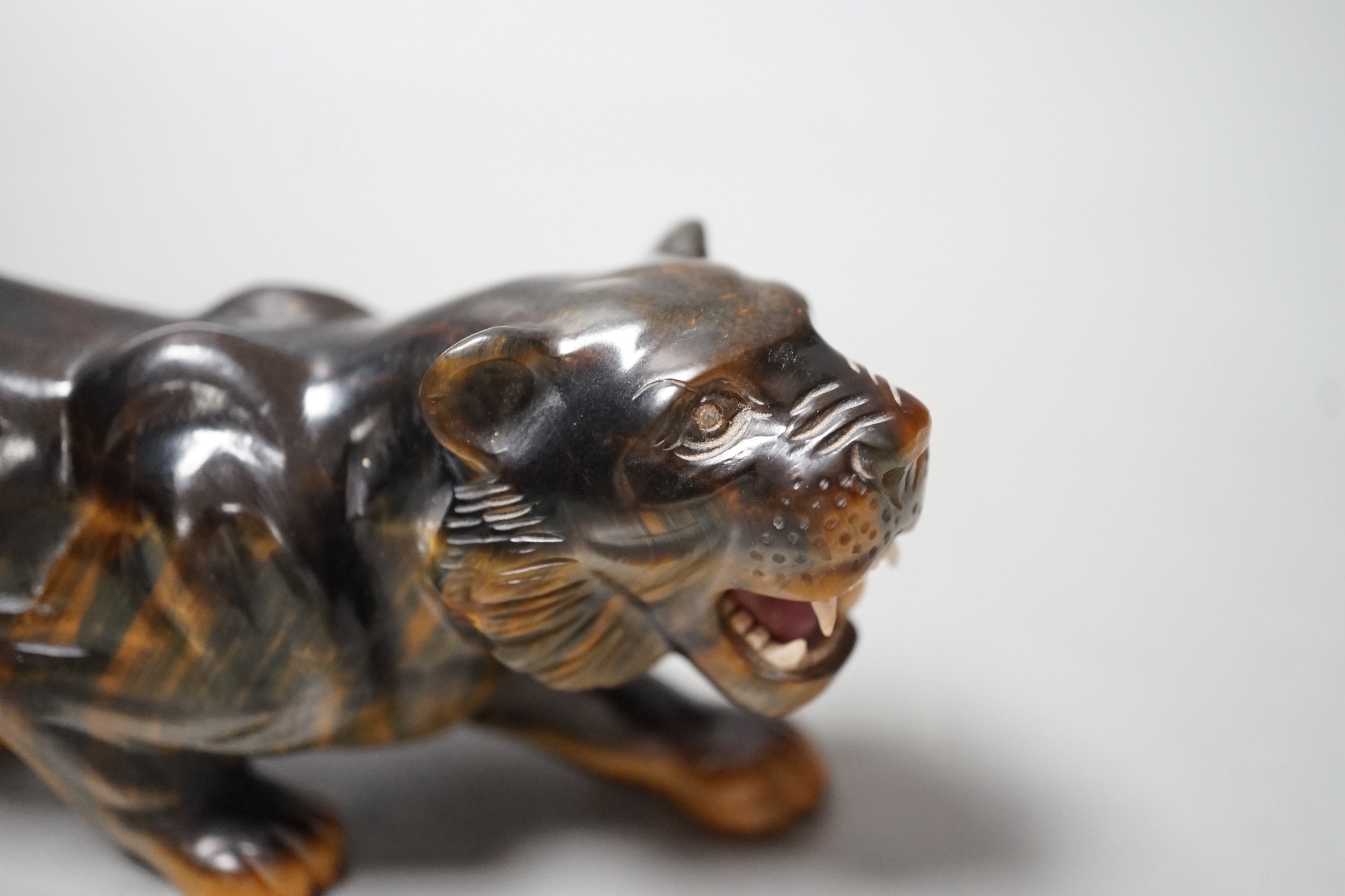 A carved tigers eye model of a tiger with paste set eyes. Makers mark ‘WG’ to paw underside. Numbered 974. 19cm long